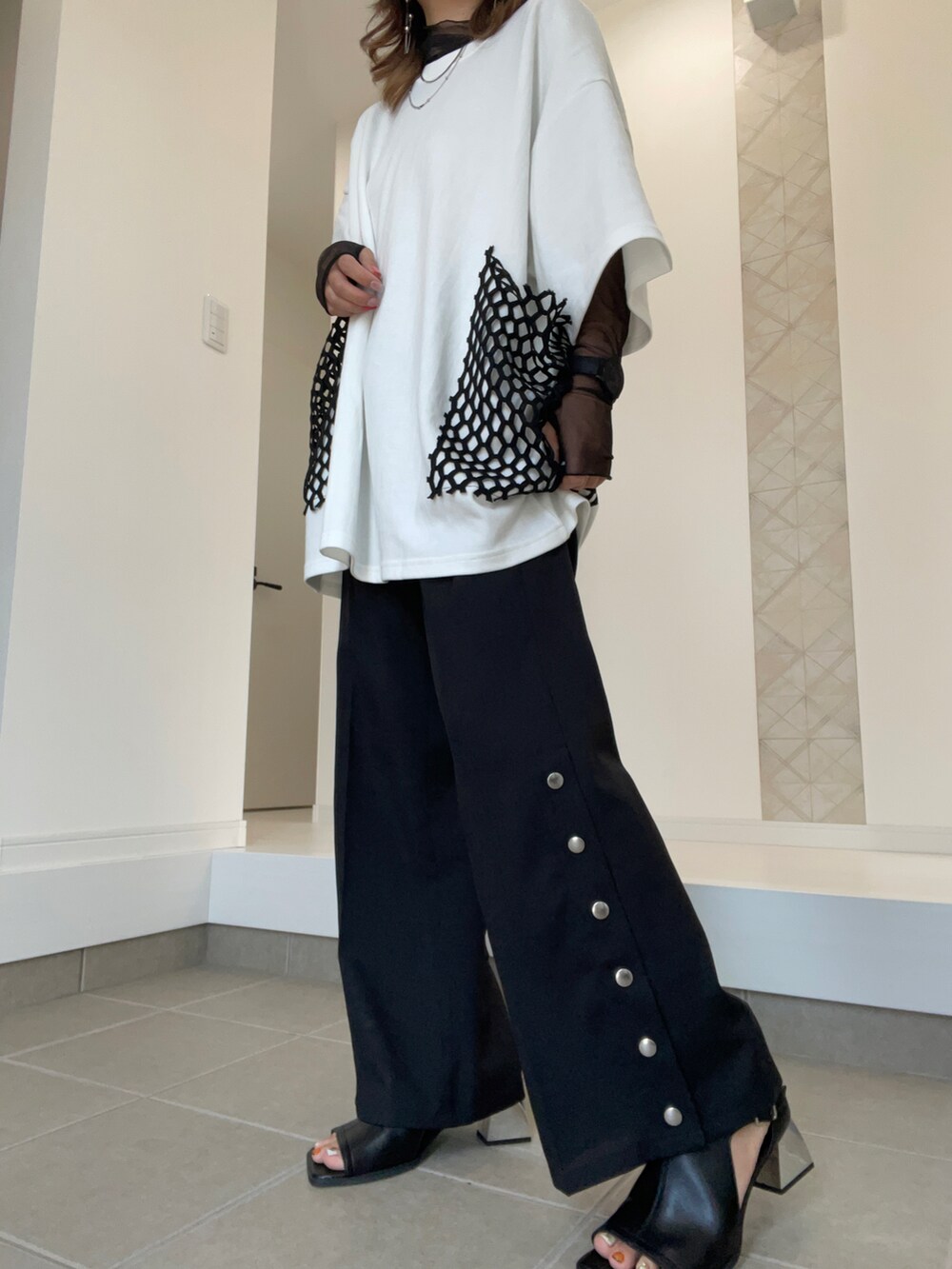 ブラック系のサンダル、ブラック系のスラックス、ホワイト系のTシャツ/カットソーを着用したレディースの春コーディネートの3枚目の写真