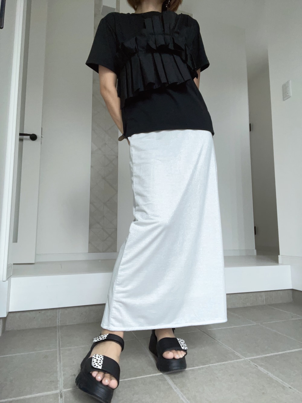 ブラック系のサンダル、ホワイト系のスカート、ブラック系のTシャツ/カットソーを着用したレディースの夏コーディネートの3枚目の写真