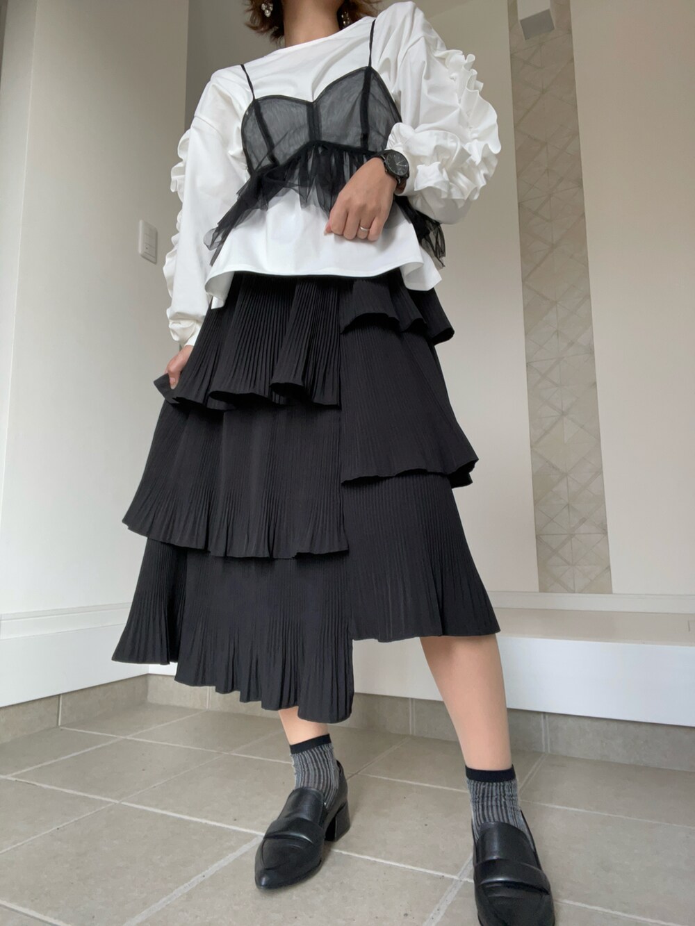 ブラック系のその他トップス、ホワイト系のTシャツ/カットソー、ブラック系のスカートを着用したレディースの春コーディネートの2枚目の写真