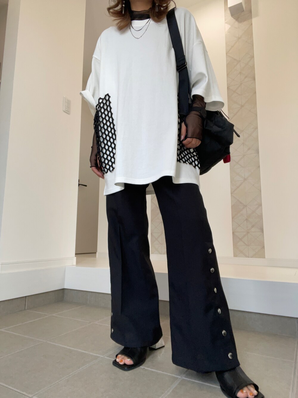 ブラック系のサンダル、ブラック系のスラックス、ホワイト系のTシャツ/カットソーを着用したレディースの春コーディネートの5枚目の写真