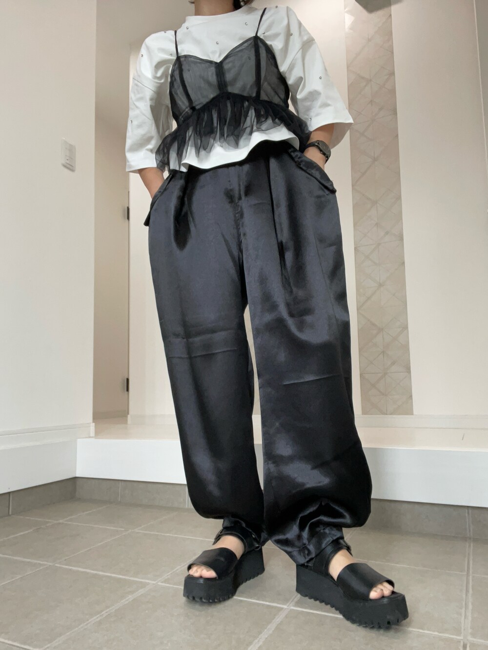 ブラック系のその他パンツ、ブラック系のサンダル、ホワイト系のTシャツ/カットソーを着用したレディースの春コーディネートの2枚目の写真