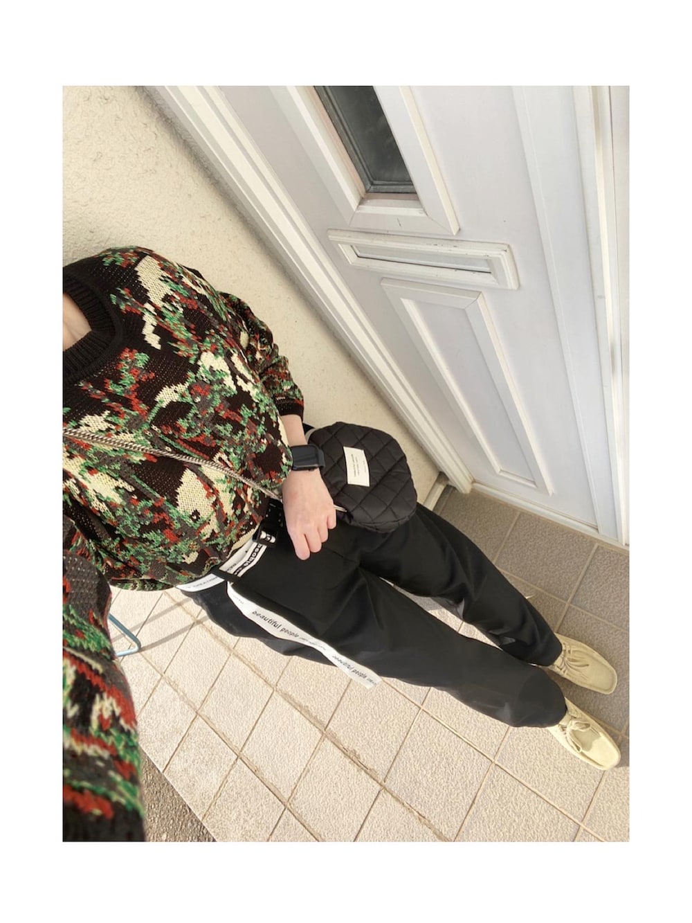 ブラック系のダウンベスト、ブラック系のトップス、ブラック系のパンツを着用したレディースの春コーディネートの2枚目の写真