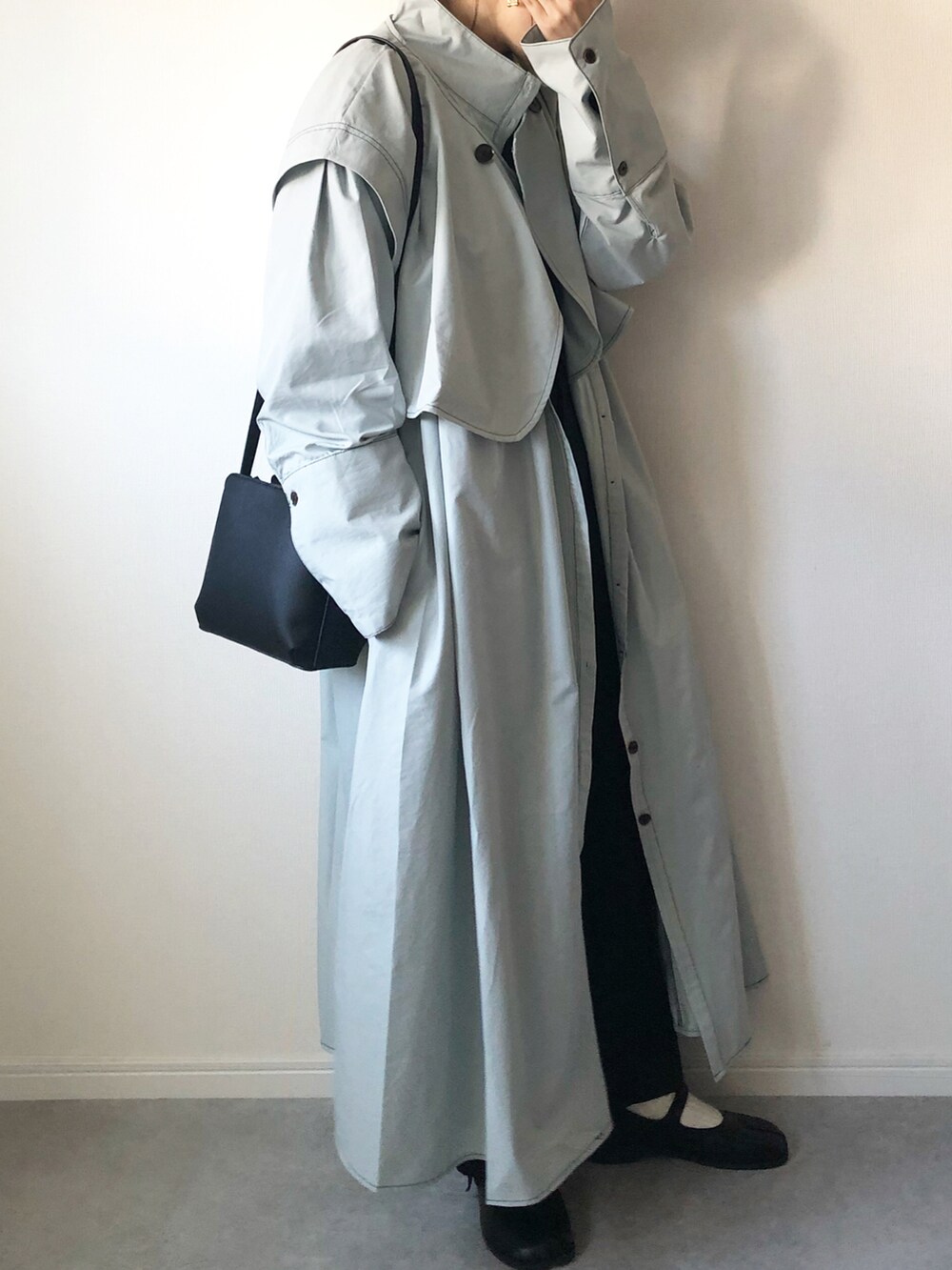 グレー系のノーカラーコート、ブラック系のショルダーバッグ、ブラック系のバレエシューズを着用したレディースの春コーディネートの3枚目の写真