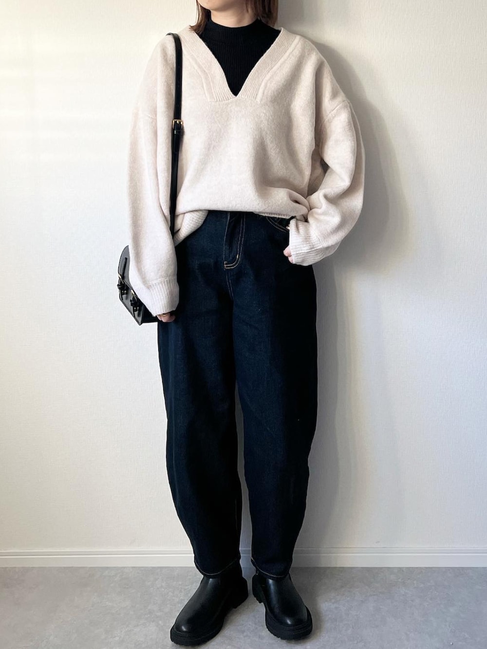 ベージュ系のニット/セーター、ブルー系のデニムパンツ、ブラック系のブーツを着用したレディースの冬コーディネートの2枚目の写真