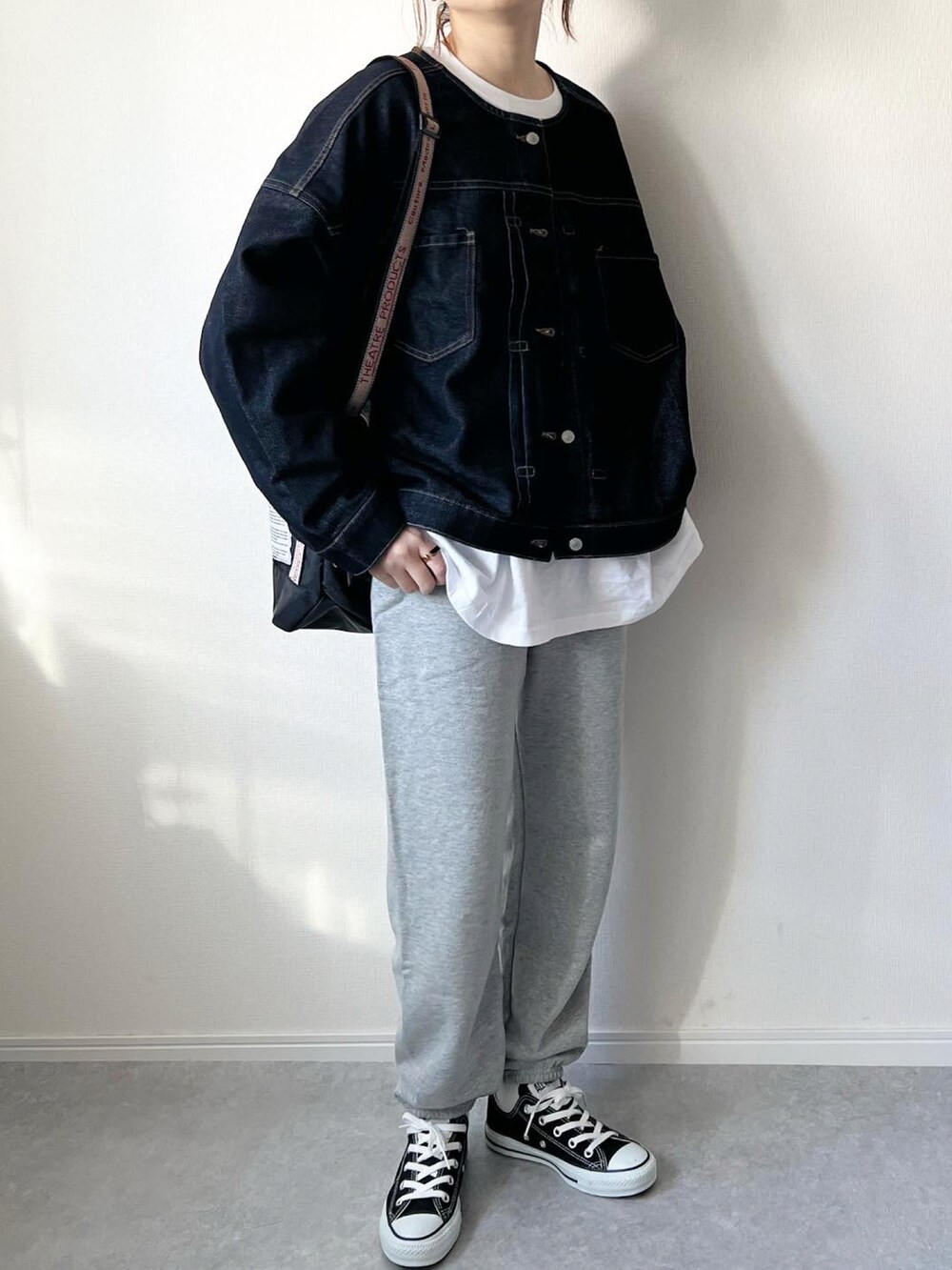 ブルー系のデニムジャケット、ホワイト系のTシャツ/カットソー、グレー系のスウェットパンツを着用したレディースの春コーディネートの2枚目の写真