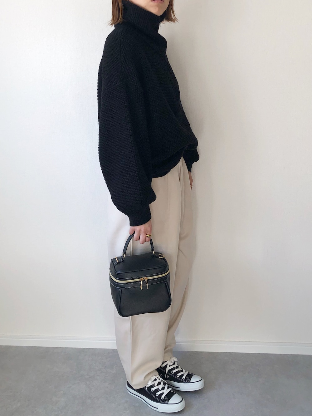 ブラック系のニット/セーター、ベージュ系のニット/セーター、ブラック系のバッグを着用したレディースの冬コーディネートの3枚目の写真