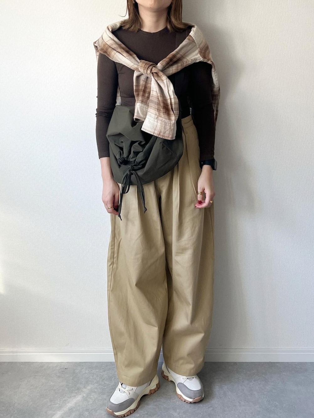 ブラウン系のTシャツ/カットソー、グリーン系のショルダーバッグ、ベージュ系のチノパンツを着用したレディースの秋コーディネートの2枚目の写真