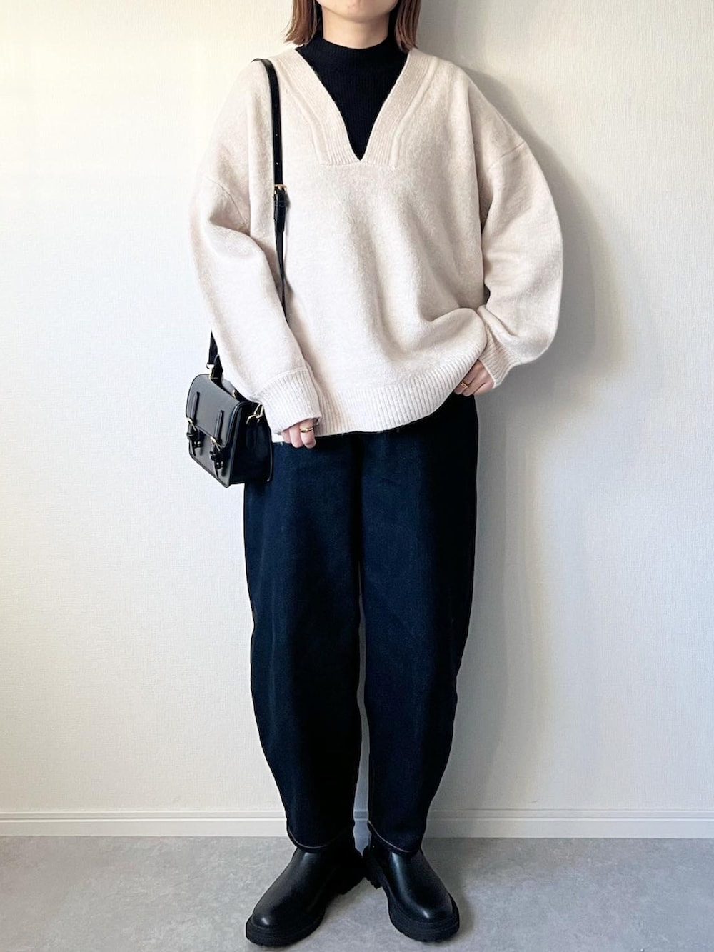 ベージュ系のニット/セーター、ブルー系のデニムパンツ、ブラック系のブーツを着用したレディースの冬コーディネートの3枚目の写真