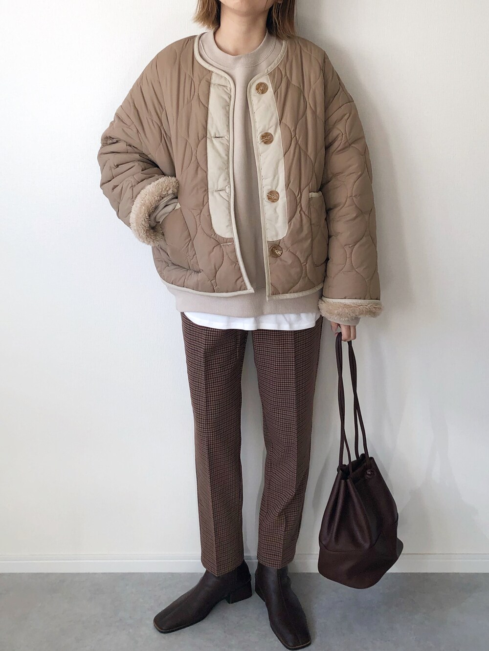 ベージュ系のブルゾン、ベージュ系のスウェット、ホワイト系のTシャツ/カットソーを着用したレディースの冬コーディネートの2枚目の写真