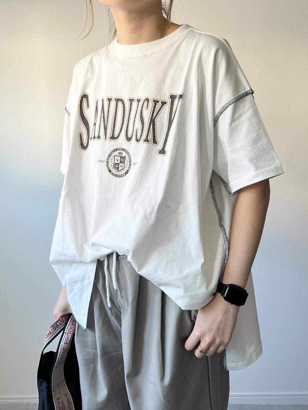 ベージュ系のパンツ、ブラック系のショルダーバッグ、ブラック系のスニーカーを着用したレディースの春コーディネートの3枚目の写真