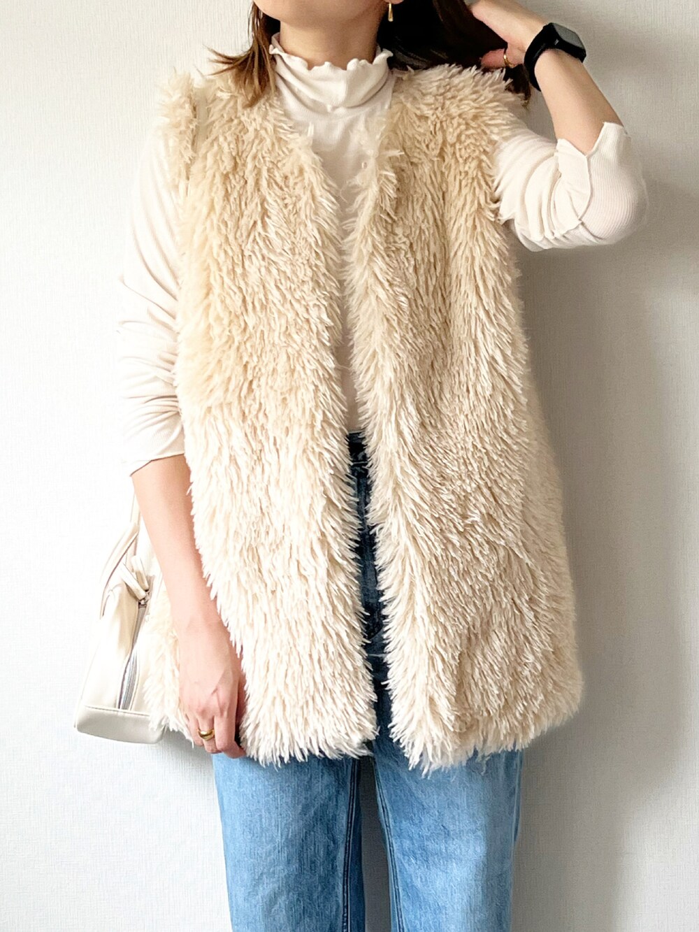 ホワイト系のベスト、ホワイト系のTシャツ/カットソー、ホワイト系のショルダーバッグを着用したレディースの秋コーディネートの2枚目の写真