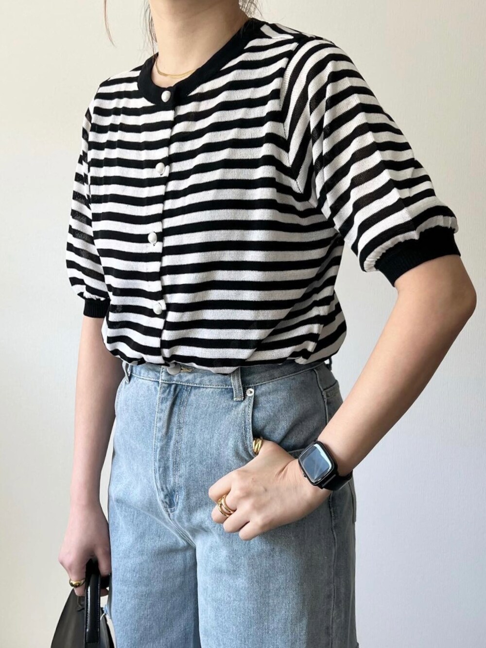 ブルー系のデニムパンツ、ブラック系のショルダーバッグ、イエロー系のバレエシューズを着用したレディースの春コーディネートの3枚目の写真