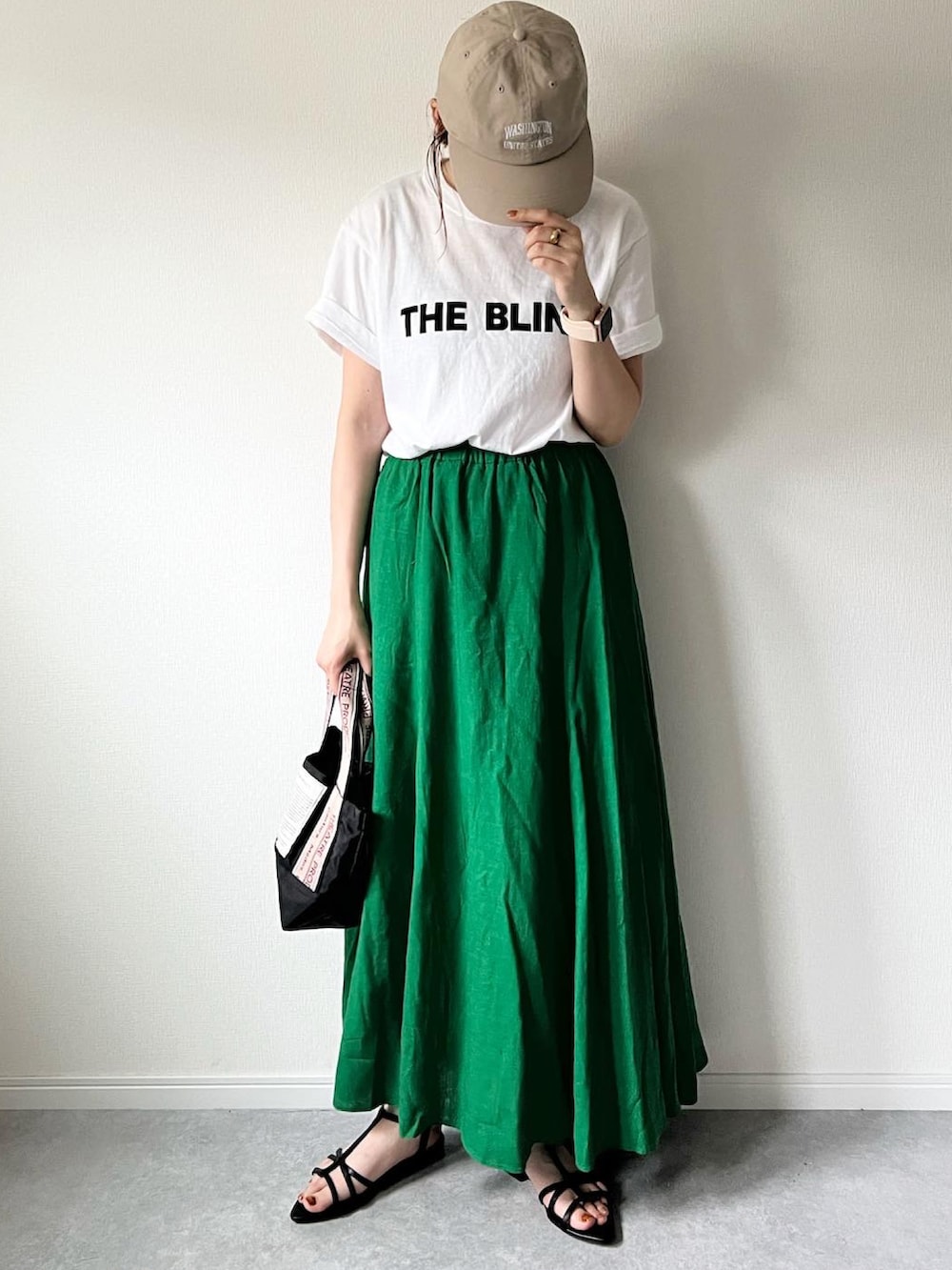 グリーン系のスカート、ホワイト系のTシャツ/カットソー、ブラック系のショルダーバッグを着用したレディースの夏コーディネートの3枚目の写真
