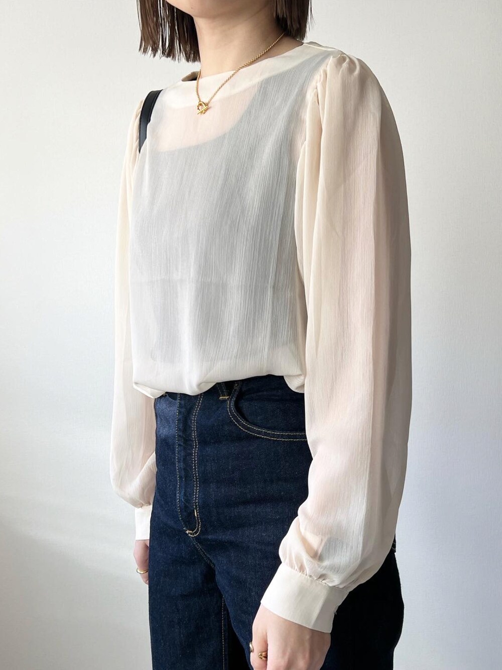 ベージュ系のシャツ/ブラウス、ブルー系のデニムパンツ、ブラック系のバッグを着用したレディースの冬コーディネートの3枚目の写真