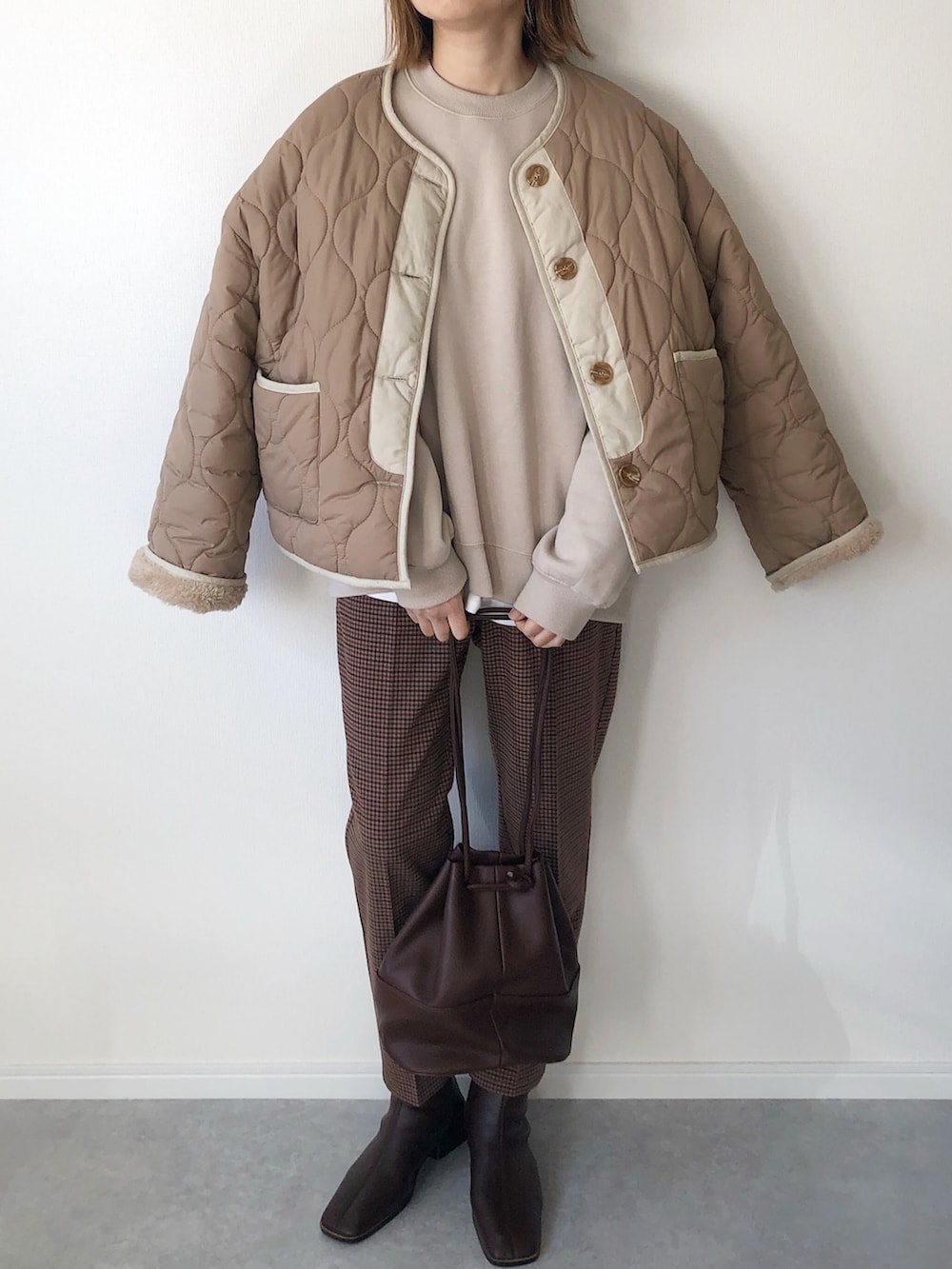 ベージュ系のブルゾン、ベージュ系のスウェット、ホワイト系のTシャツ/カットソーを着用したレディースの冬コーディネートの3枚目の写真