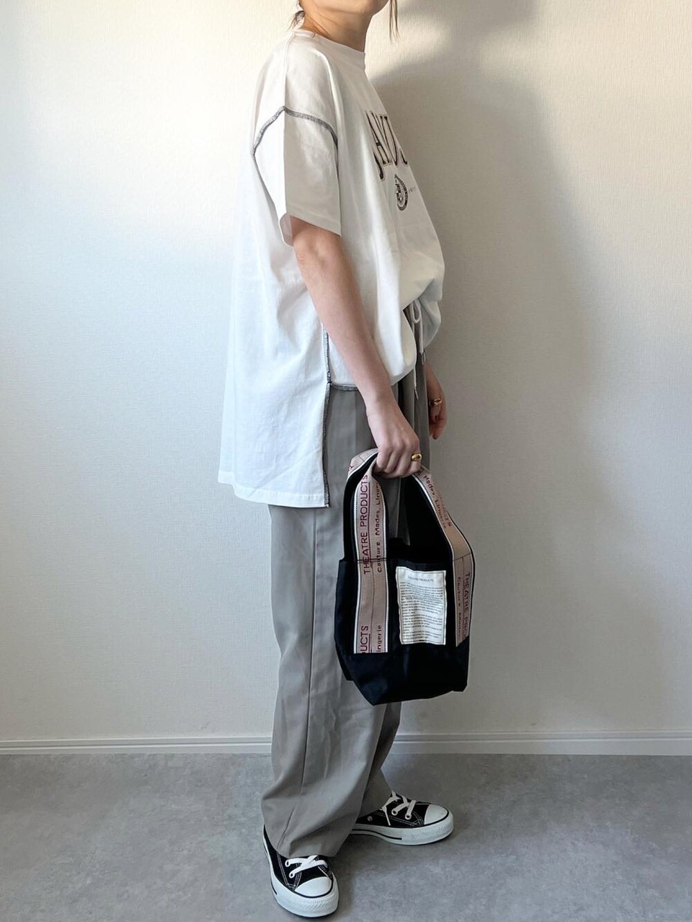 ベージュ系のパンツ、ブラック系のショルダーバッグ、ブラック系のスニーカーを着用したレディースの春コーディネートの2枚目の写真