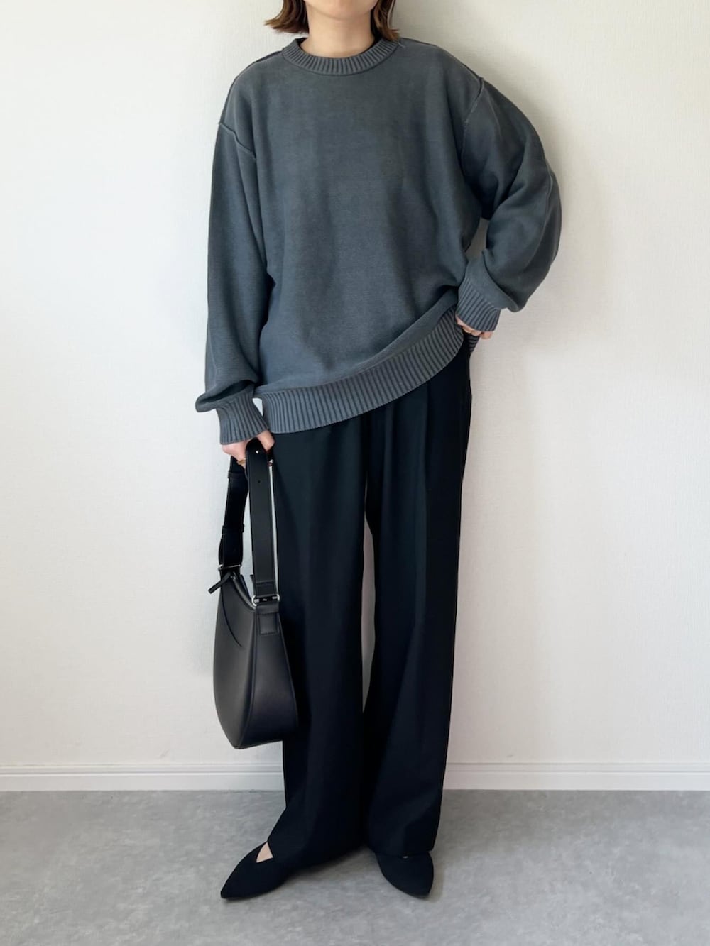 グレー系のニット/セーター、ブラック系のパンツ、ブラック系のバッグを着用したレディースの春コーディネートの3枚目の写真