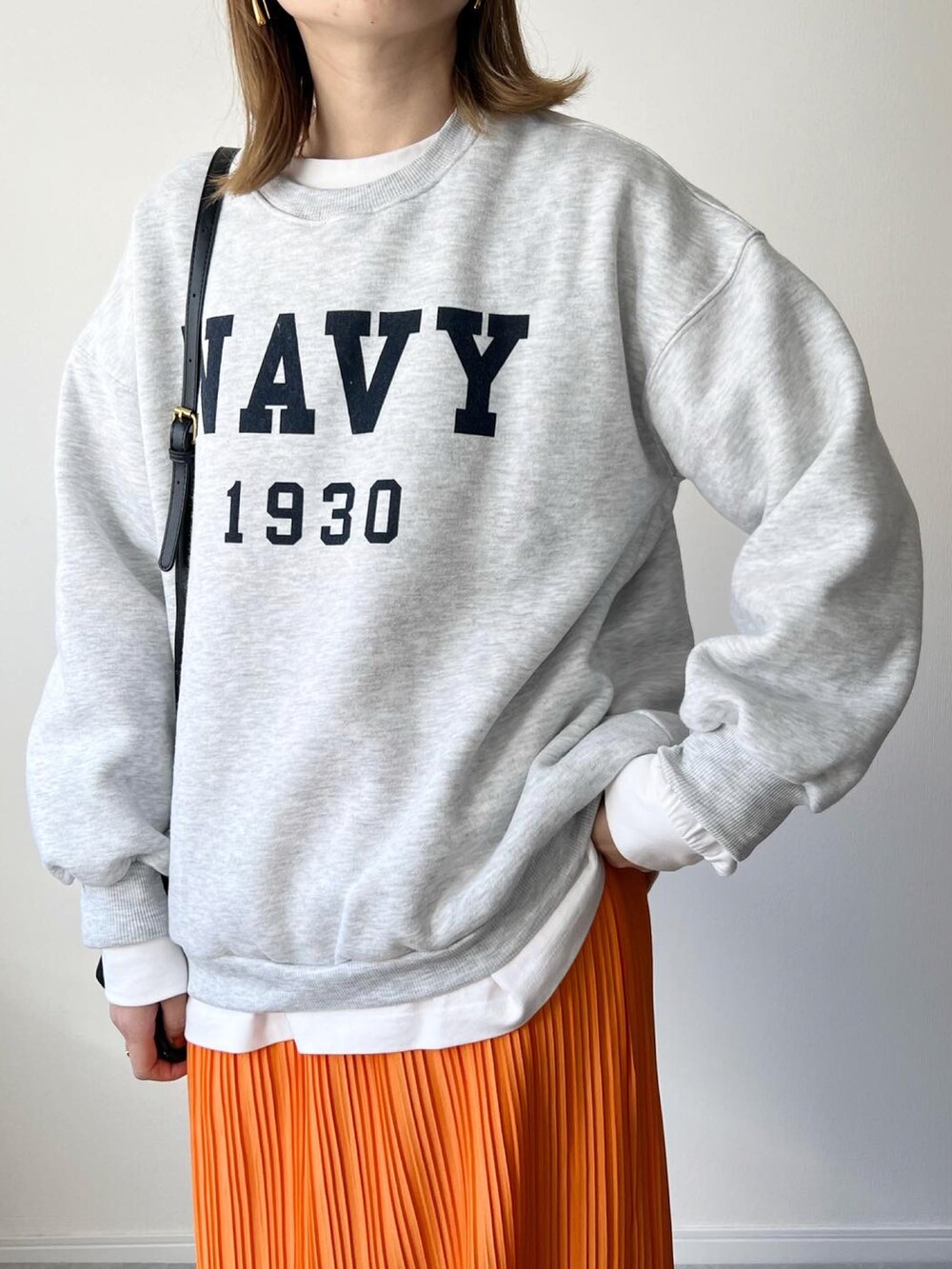 グレー系のスウェット、ブラック系のバッグ、オレンジ系のスカートを着用したレディースの秋コーディネートの3枚目の写真