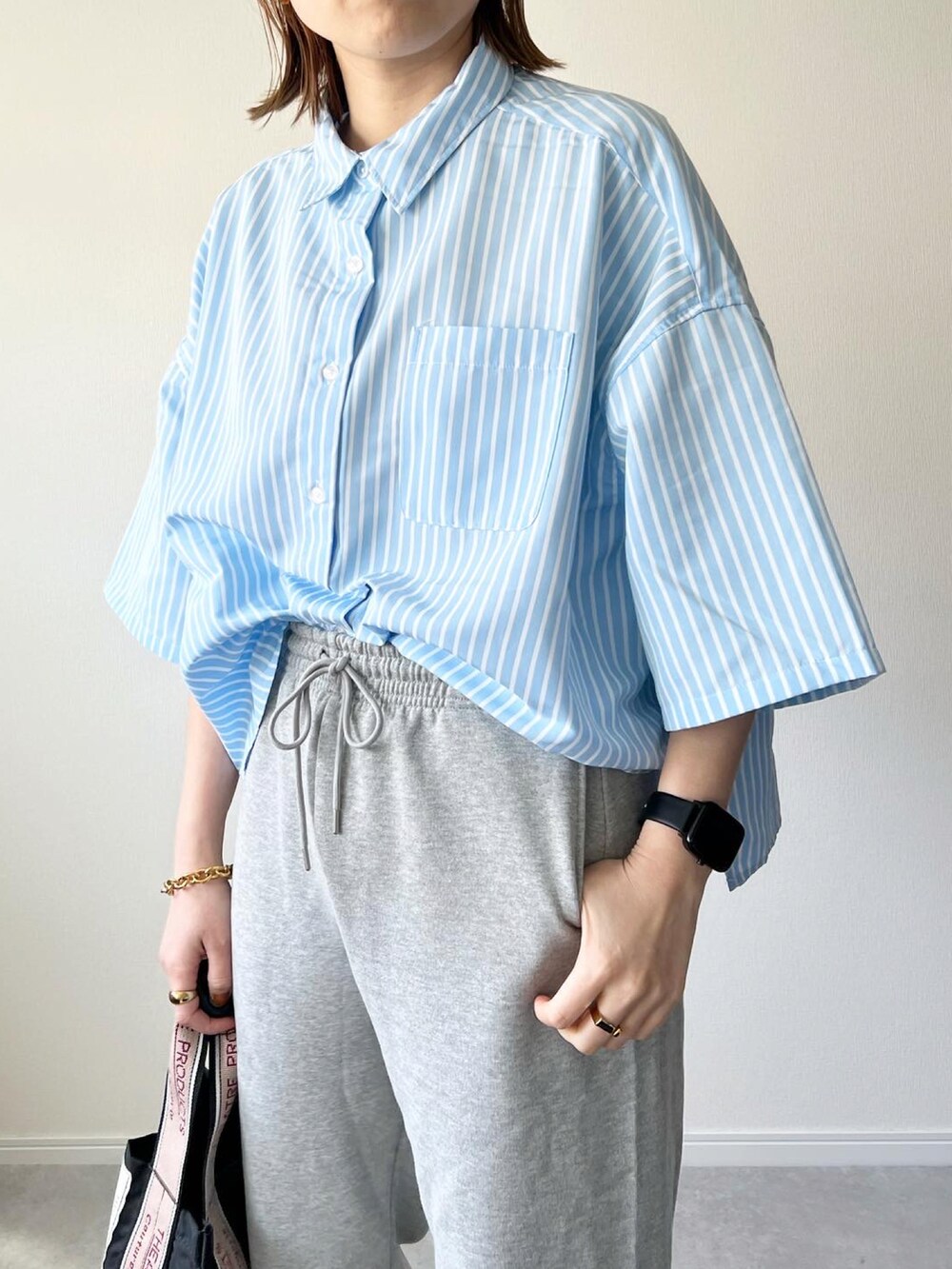 グレー系のスウェットパンツ、ブラック系のショルダーバッグ、ブラック系のスニーカーを着用したレディースの春コーディネートの3枚目の写真