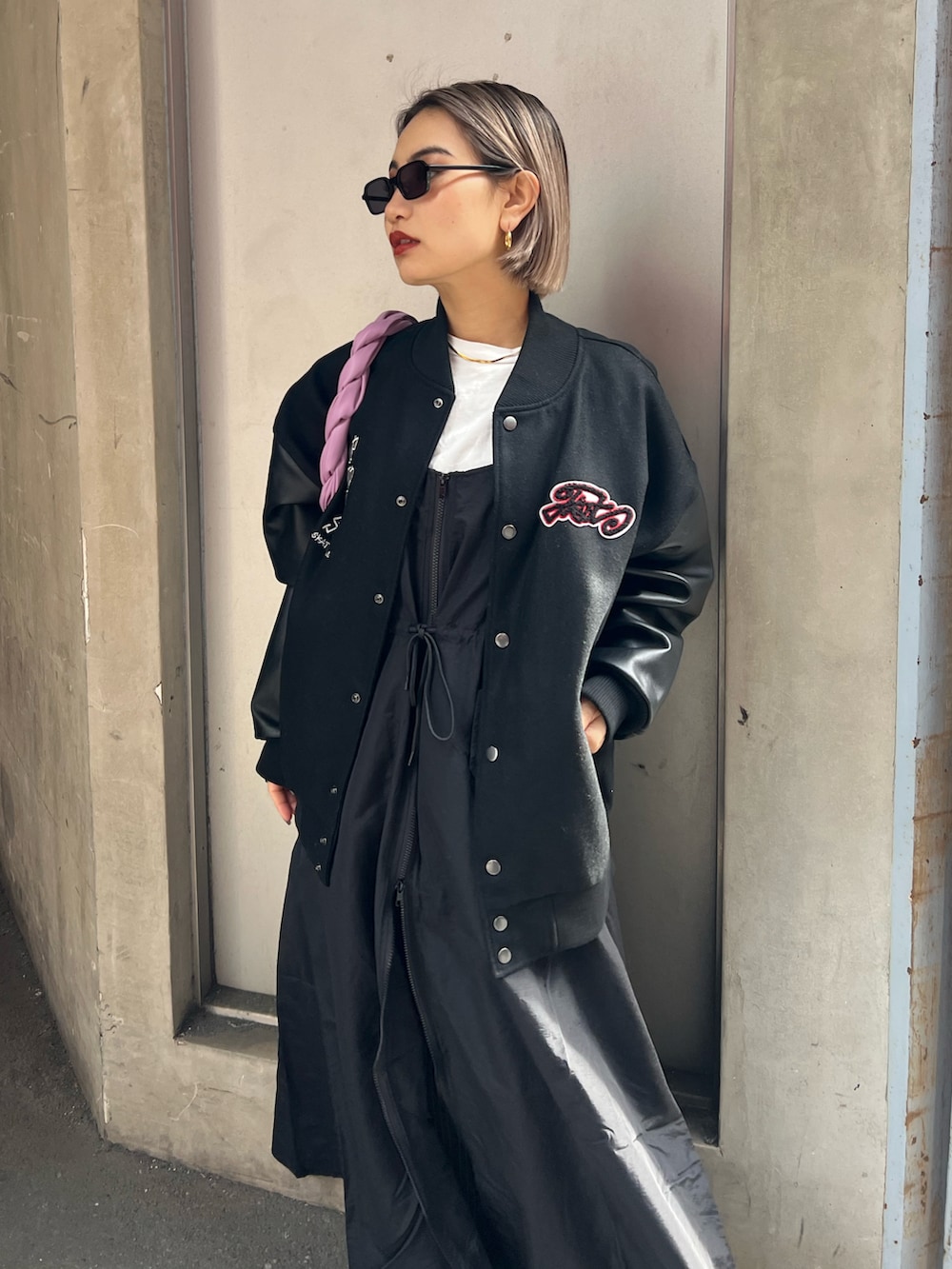 ブラック系のスタジャン、ブラック系のワンピース/ドレス、グリーン系のハンドバッグを着用したレディースの冬コーディネートの4枚目の写真