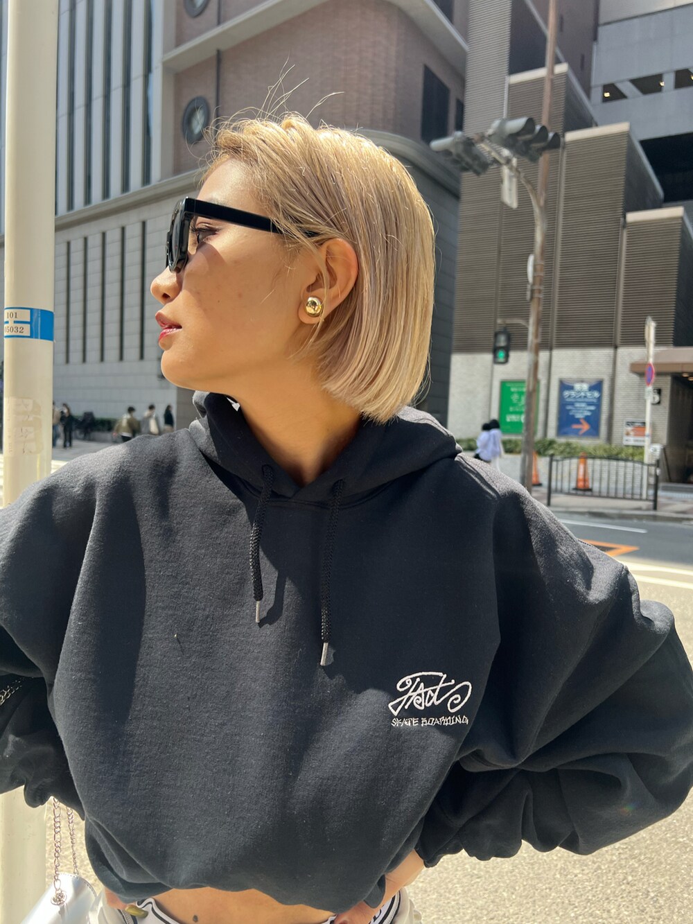 ブルー系のデニムパンツ、シルバー系のショルダーバッグ、グレー系のパーカーを着用したレディースの春コーディネートの5枚目の写真