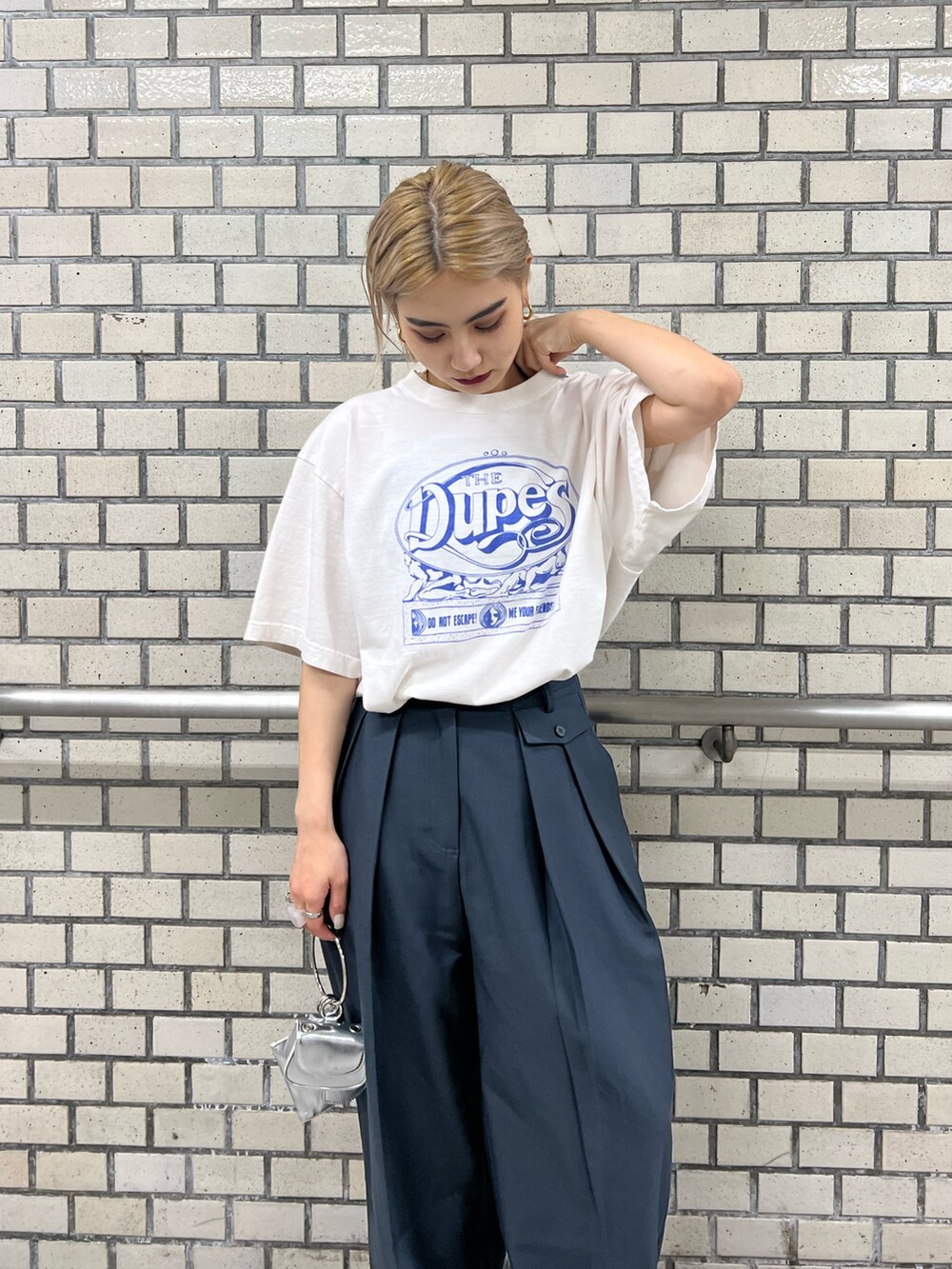 ブラック系のブーツ、ブルー系のスラックス、ホワイト系のTシャツ/カットソーを着用したレディースの夏コーディネートの2枚目の写真