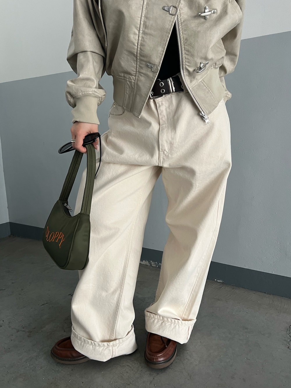 ホワイト系のブルゾン、ブラック系のショルダーバッグ、ホワイト系のデニムパンツを着用したレディースの春コーディネートの4枚目の写真