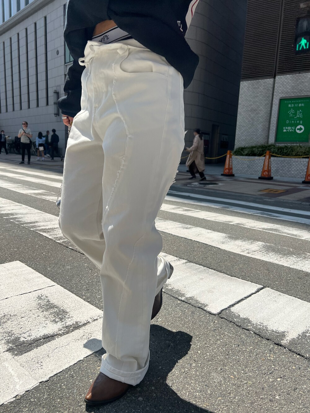 ブルー系のデニムパンツ、シルバー系のショルダーバッグ、グレー系のパーカーを着用したレディースの春コーディネートの2枚目の写真