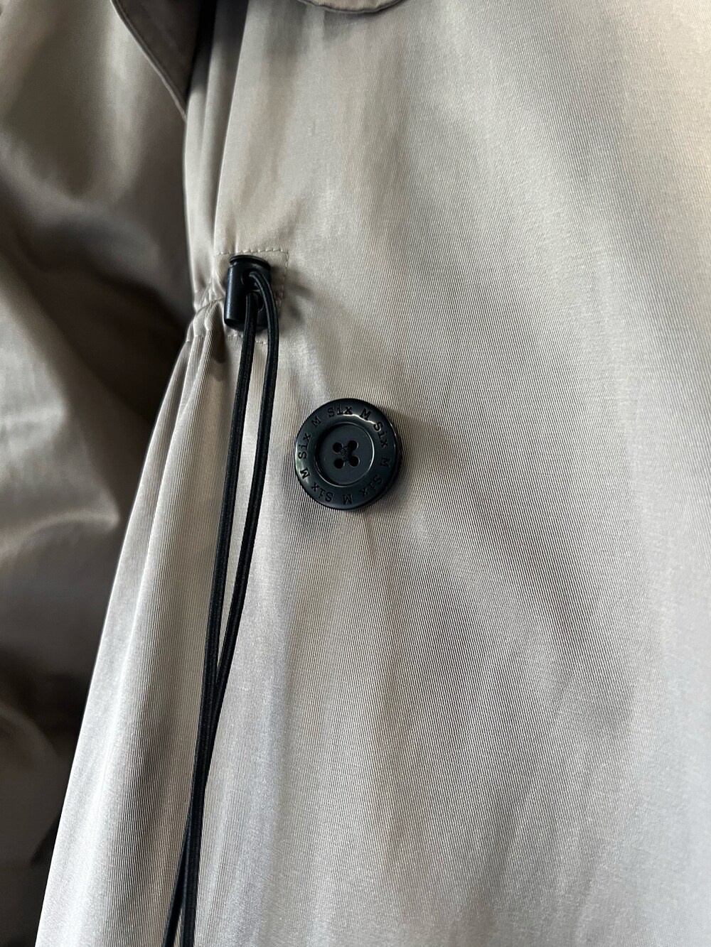 ブルー系のスニーカー、ベージュ系のトレンチコート、グレー系のスウェットパンツを着用したレディースの秋コーディネートの4枚目の写真