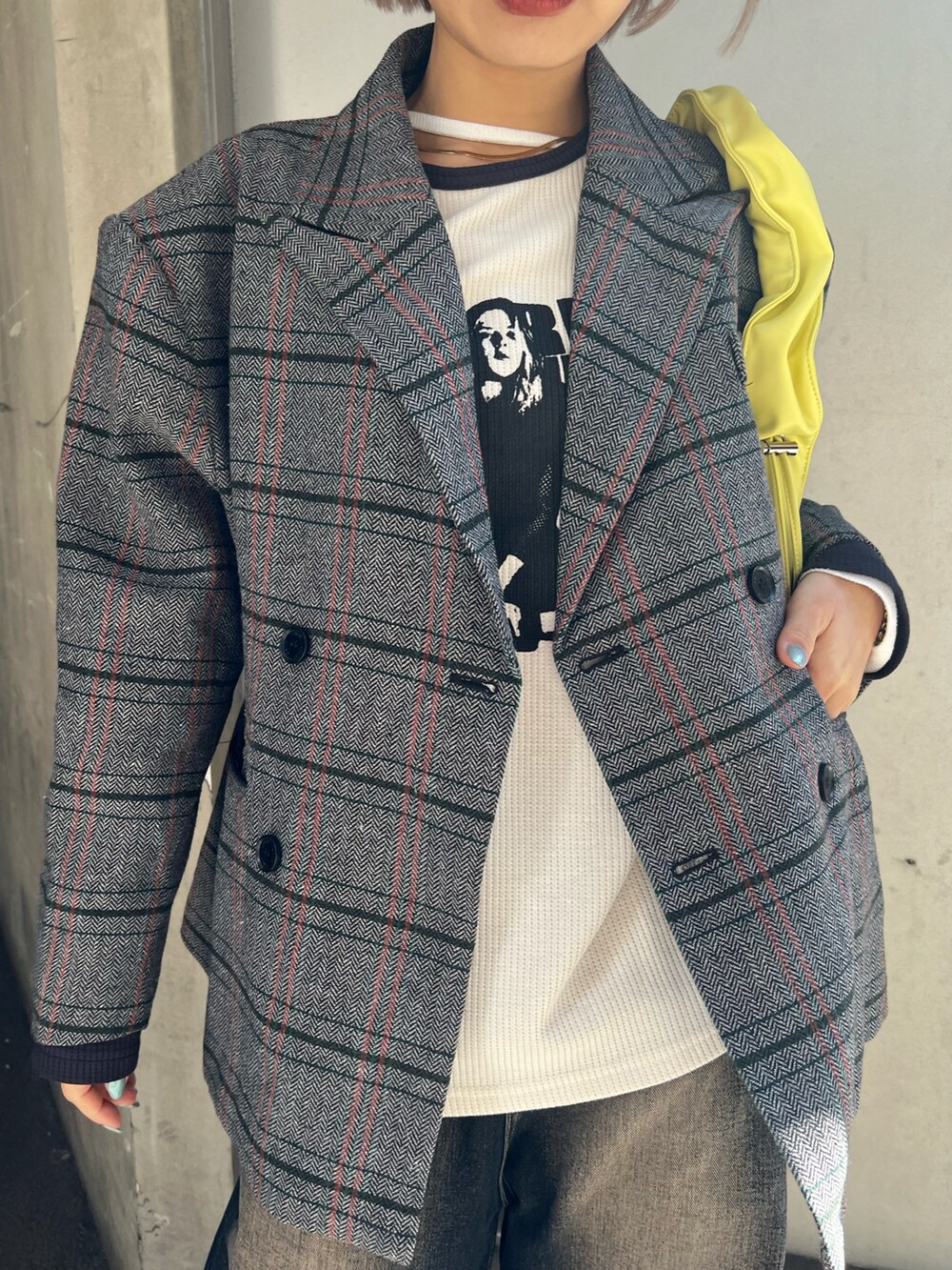 イエロー系のショルダーバッグ、グレー系のテーラードジャケット、ブルー系のデニムパンツを着用したレディースの冬コーディネートの3枚目の写真