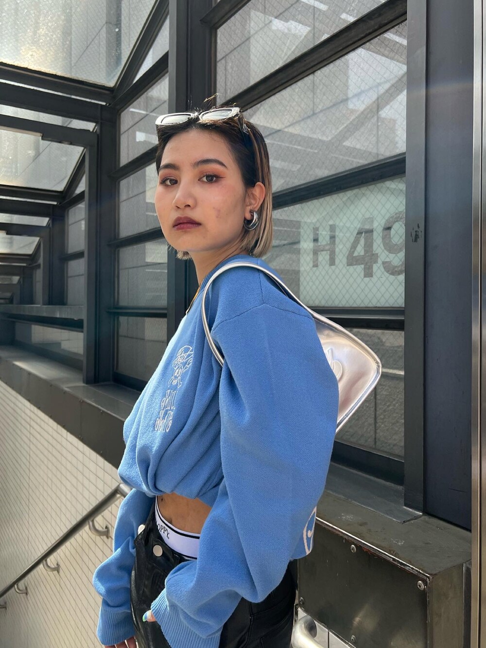 ブラック系のその他パンツ、ブルー系のニット/セーター、ホワイト系のその他パンツを着用したレディースの春コーディネートの4枚目の写真