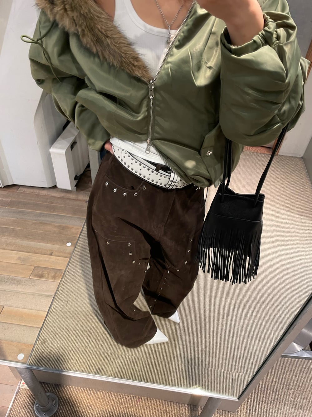 イエロー系のパンツ、グリーン系のブルゾンを着用したレディースの秋コーディネートの3枚目の写真