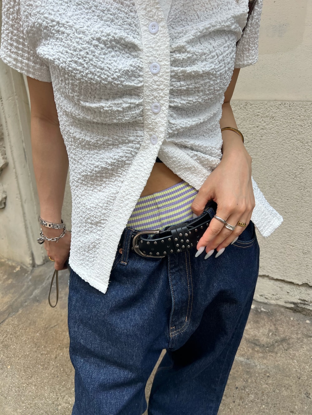 ブルー系のデニムパンツ、ホワイト系のシャツ/ブラウス、ブラック系のショルダーバッグを着用したレディースの夏コーディネートの5枚目の写真