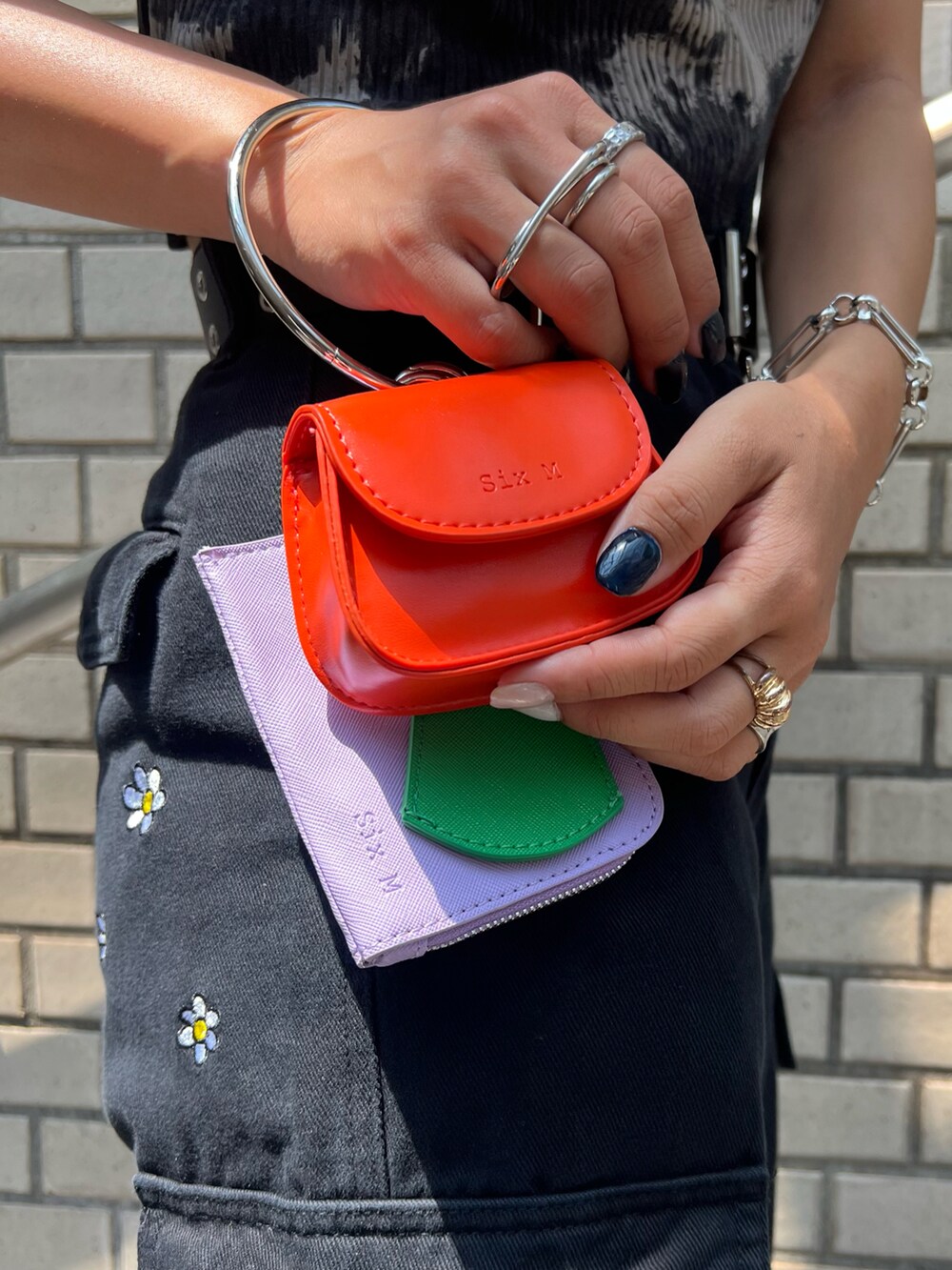 ブラック系のカーゴパンツ、ブラック系のスニーカー、イエロー系のショルダーバッグを着用したレディースの夏コーディネートの3枚目の写真