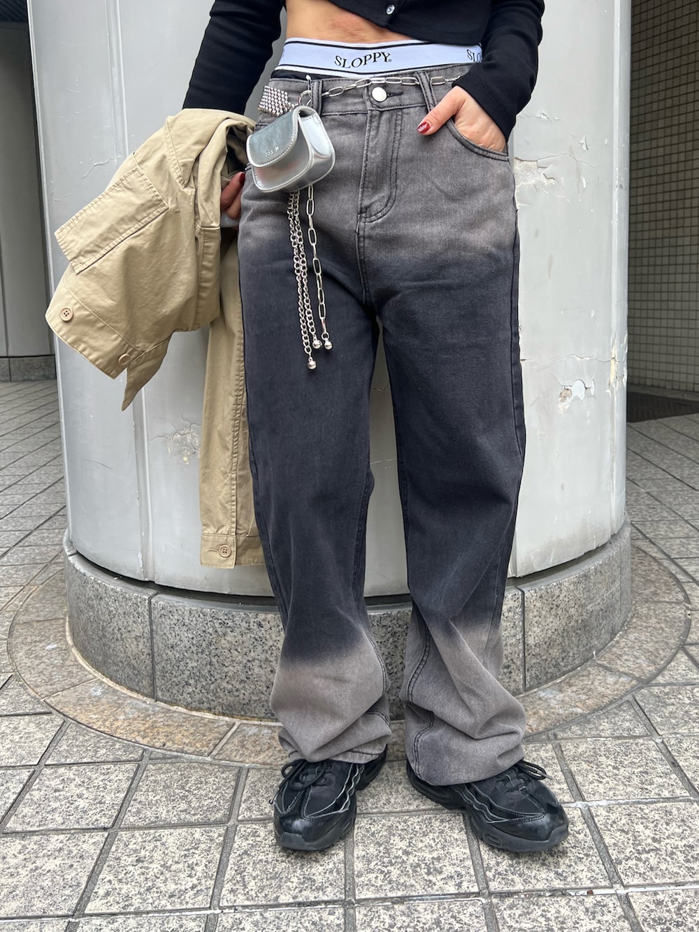 ブラック系のデニムパンツ、ベージュ系のミリタリージャケット、シルバー系のショルダーバッグを着用したレディースの春コーディネートの5枚目の写真