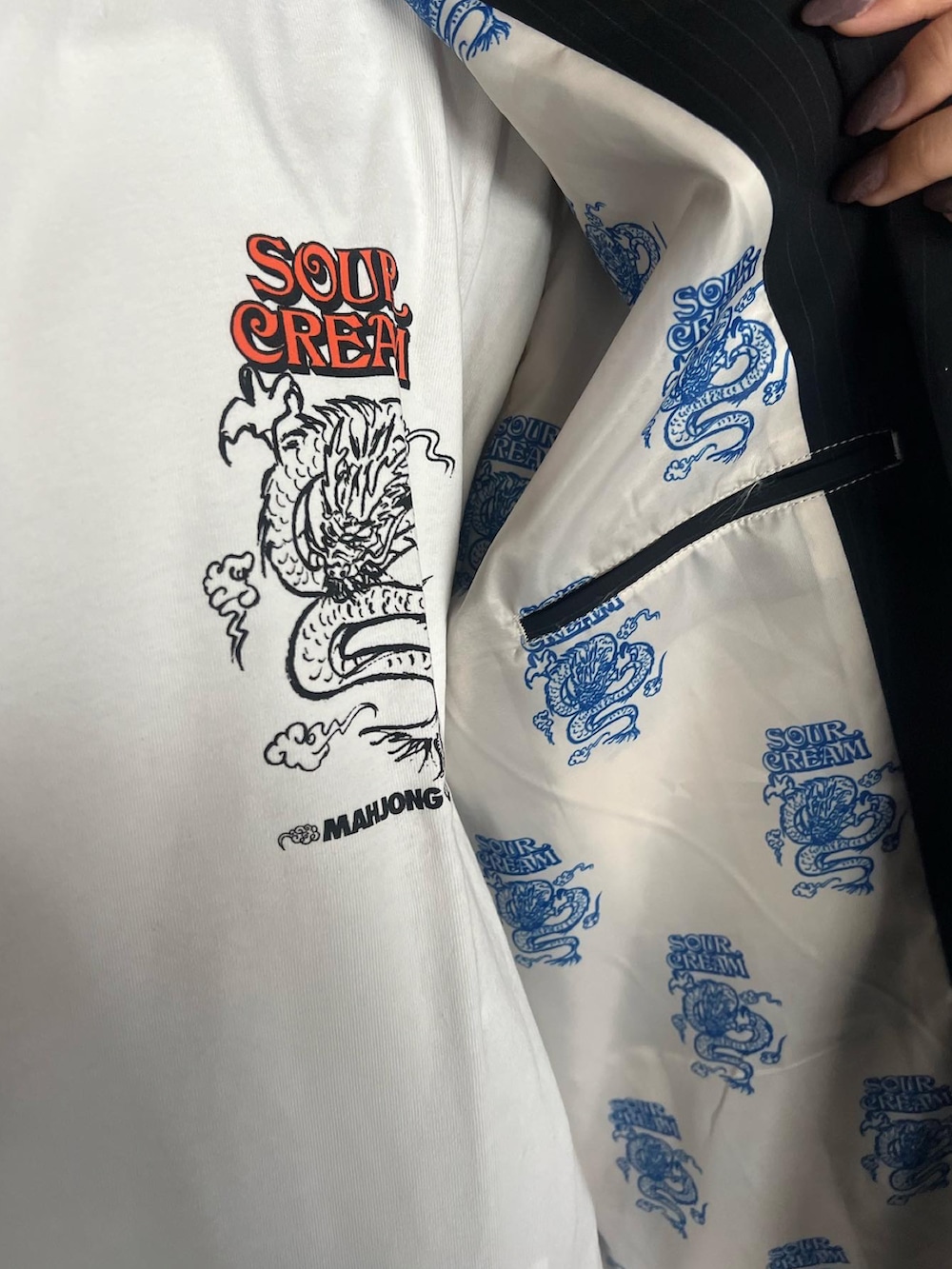 ブラック系のテーラードジャケット、ブラック系のブーツ、ホワイト系のTシャツ/カットソーを着用したレディースの秋コーディネートの5枚目の写真