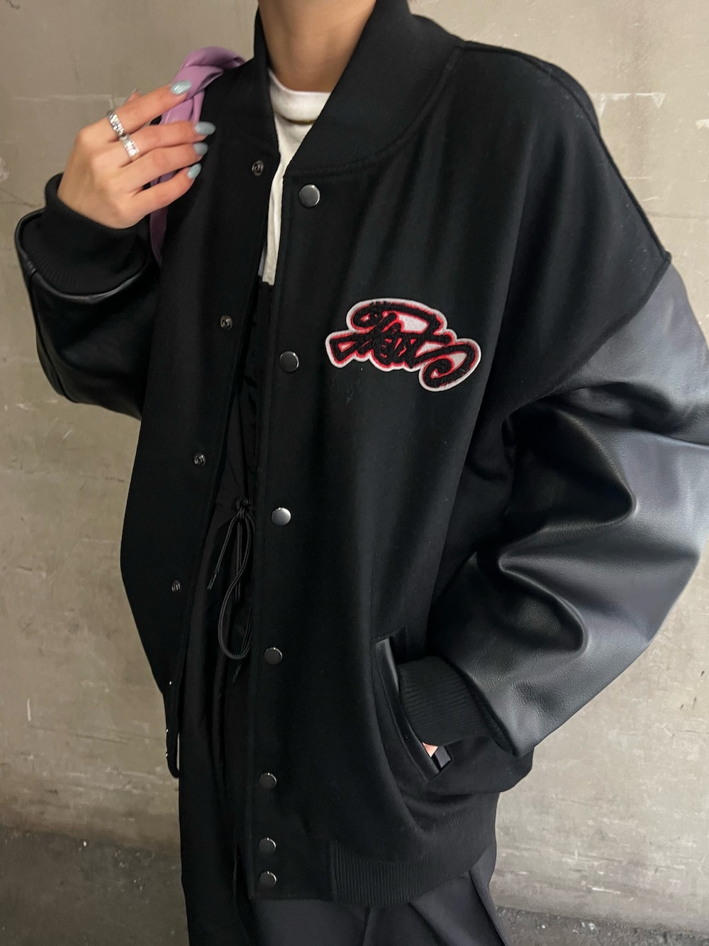 ブラック系のスタジャン、ブラック系のワンピース/ドレス、グリーン系のハンドバッグを着用したレディースの冬コーディネートの3枚目の写真