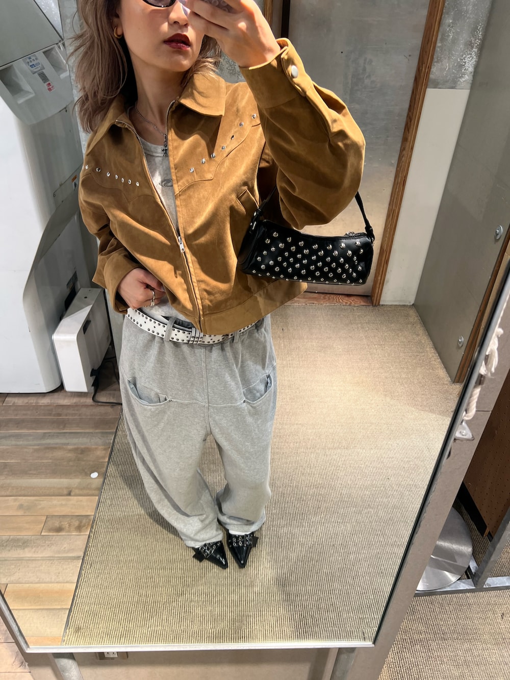 グレー系のスウェットパンツ、イエロー系のブルゾン、ブラック系のショルダーバッグを着用したレディースの秋コーディネートの2枚目の写真