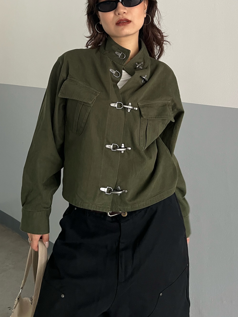 グリーン系のミリタリージャケット、ブラック系のその他パンツを着用したレディースの春コーディネートの2枚目の写真