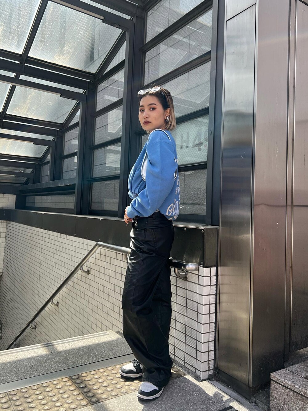 ブラック系のその他パンツ、ブルー系のニット/セーター、ホワイト系のその他パンツを着用したレディースの春コーディネートの2枚目の写真