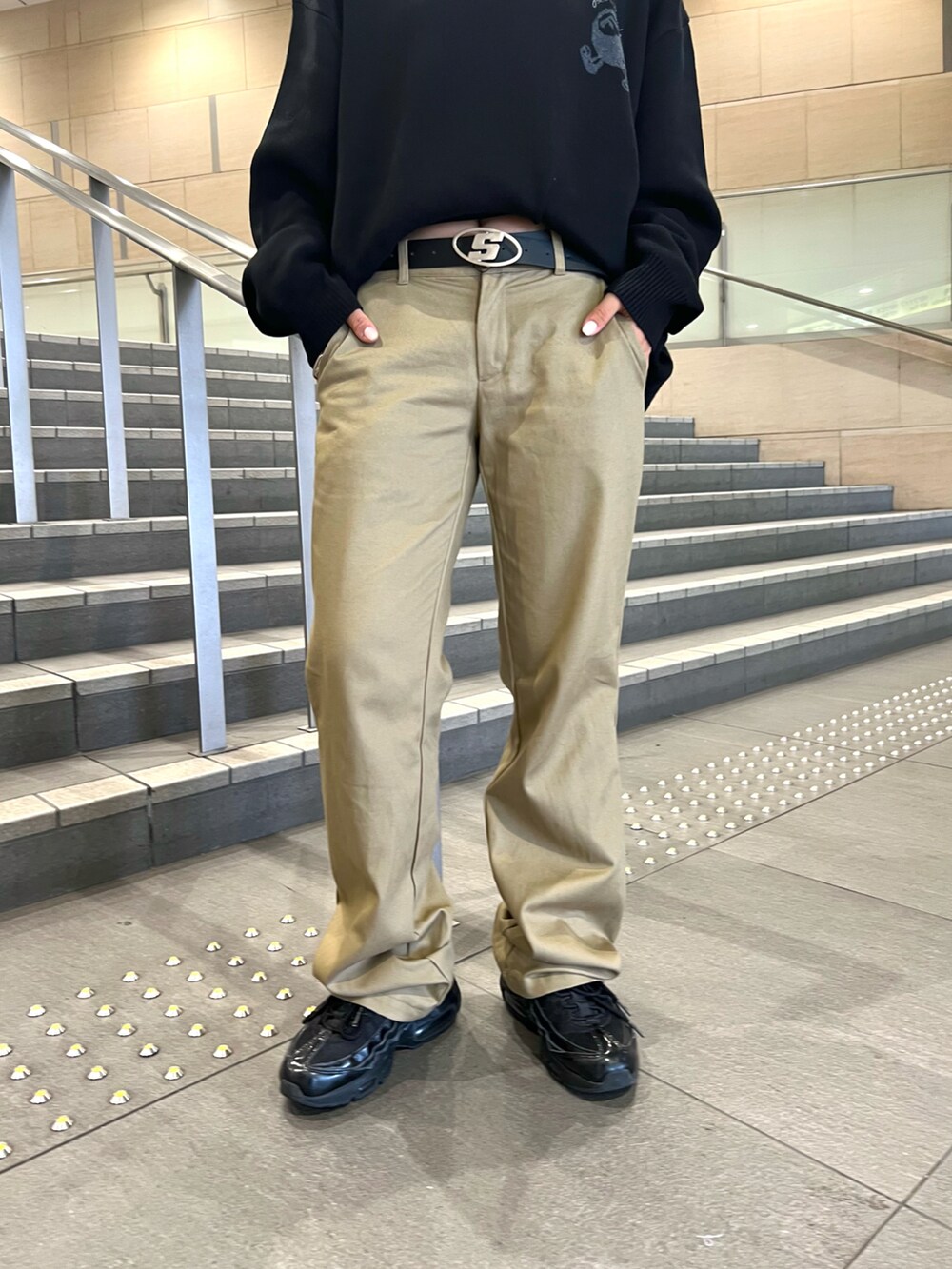 ブラック系のニット/セーター、ベージュ系のスラックスを着用したレディースの秋コーディネートの2枚目の写真