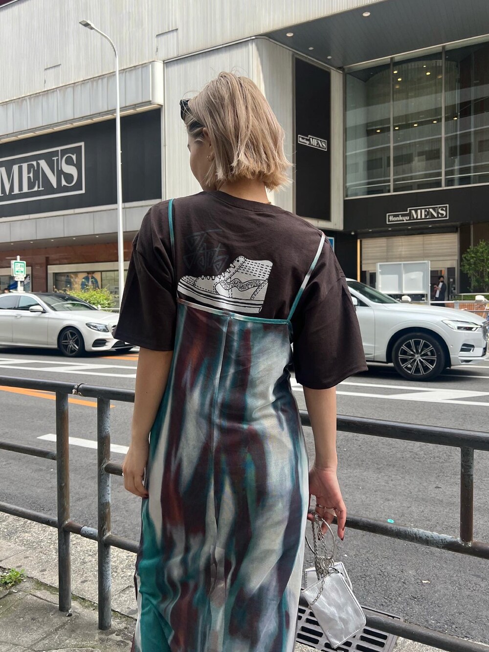 ブラック系のデニムパンツ、ブラウン系のTシャツ/カットソー、パープル系のワンピースを着用したレディースの春コーディネートの2枚目の写真