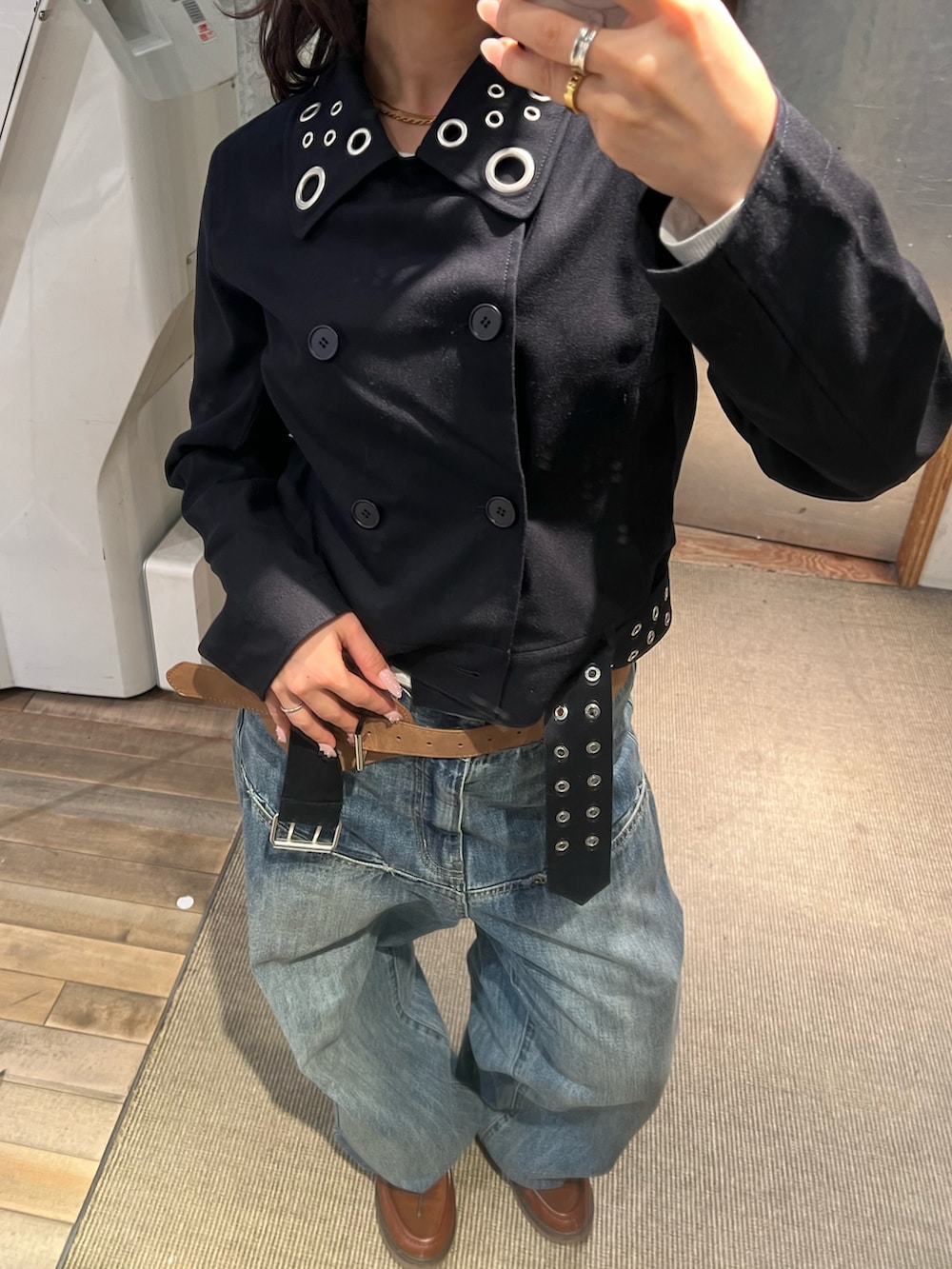 グレー系のピーコート、ブルー系のデニムパンツ、ベージュ系のベルトを着用したレディースの冬コーディネートの2枚目の写真