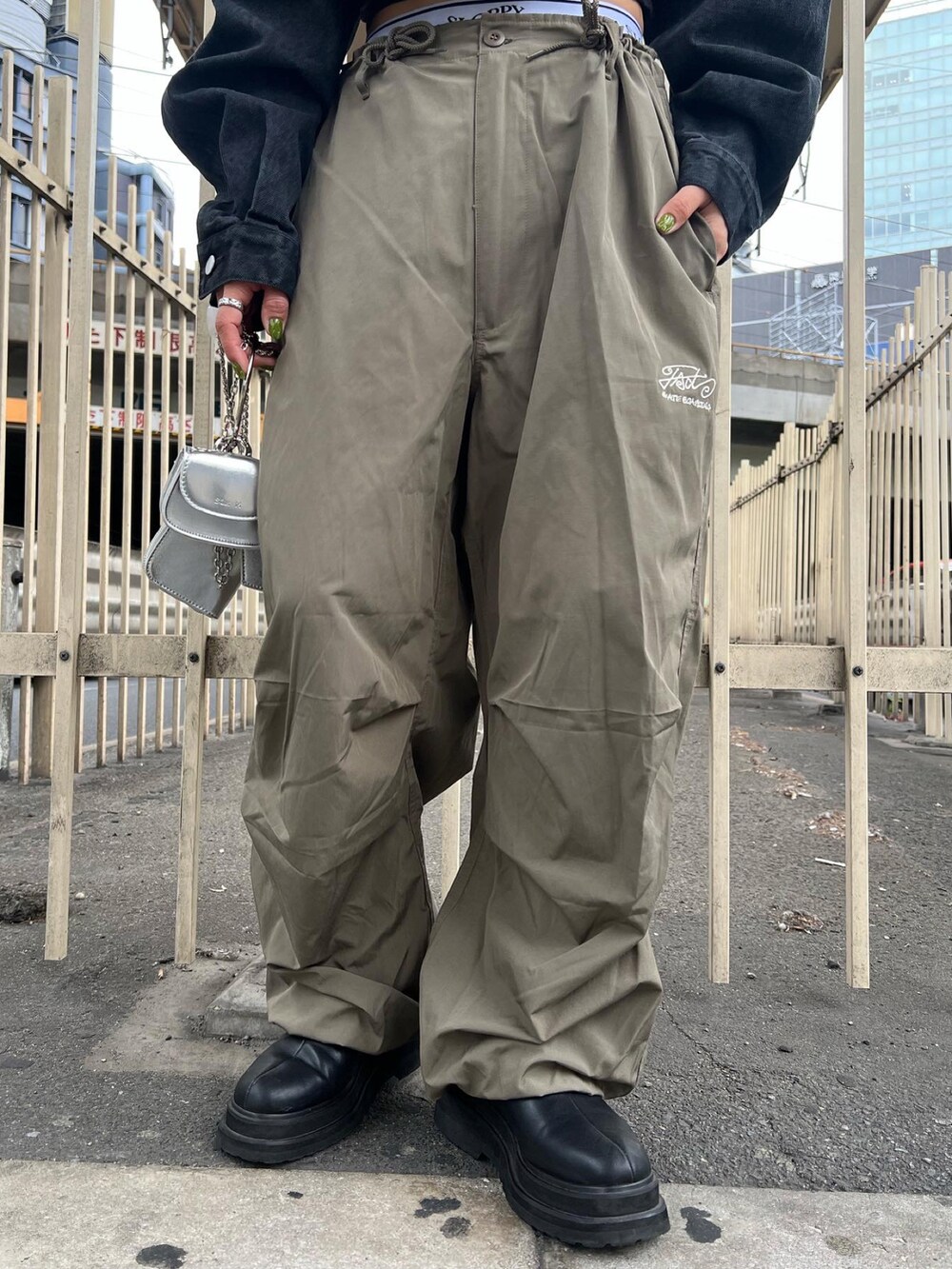 ホワイト系のカーゴパンツ、ブラック系のデニムジャケット、シルバー系のショルダーバッグを着用したレディースの春コーディネートの3枚目の写真