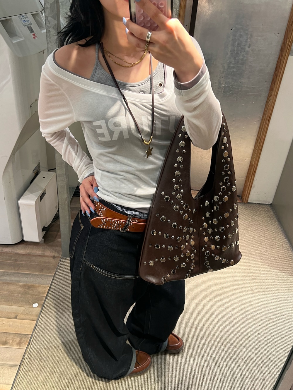 ブルー系のデニムパンツ、ホワイト系のTシャツ/カットソー、ブラウン系のショルダーバッグを着用したレディースの春コーディネートの2枚目の写真