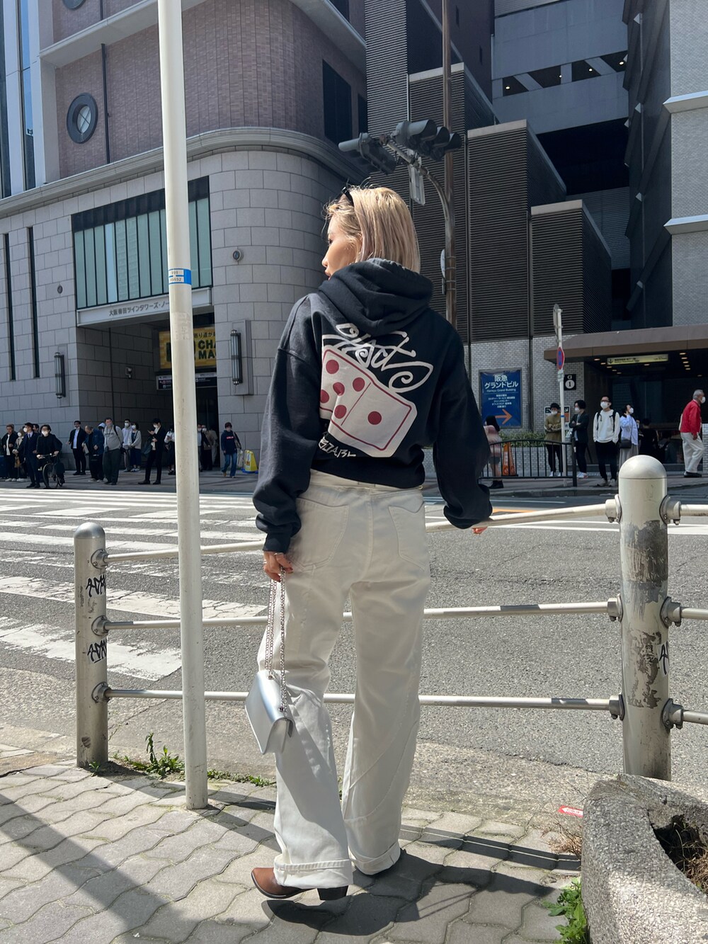 ブルー系のデニムパンツ、シルバー系のショルダーバッグ、グレー系のパーカーを着用したレディースの春コーディネートの3枚目の写真