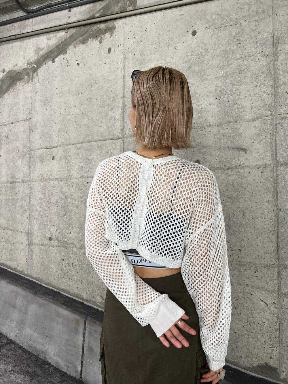 グリーン系のスカート、ホワイト系のニット/セーター、グレー系のキャミソールを着用したレディースの夏コーディネートの4枚目の写真