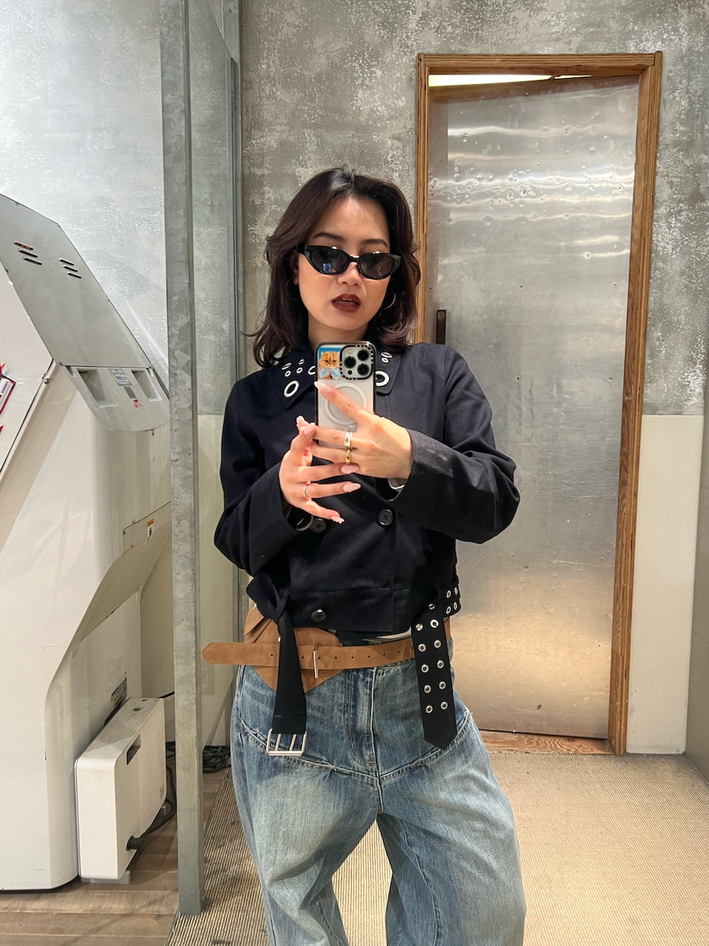 グレー系のピーコート、ブルー系のデニムパンツ、ベージュ系のベルトを着用したレディースの冬コーディネートの3枚目の写真