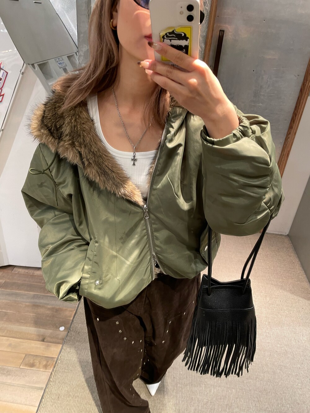 イエロー系のパンツ、グリーン系のブルゾンを着用したレディースの秋コーディネートの4枚目の写真