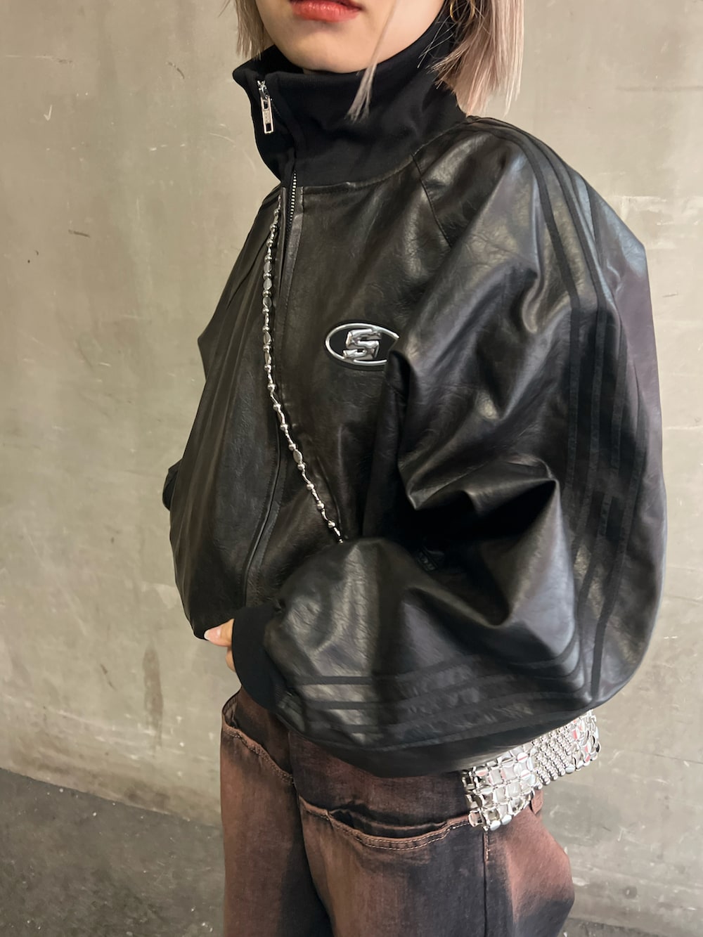 ブルー系のデニムパンツ、ブラック系のブーツ、シルバー系のショルダーバッグを着用したレディースの冬コーディネートの3枚目の写真